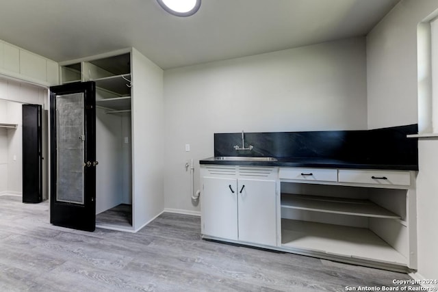 interior space featuring white cabinetry, sink, and light hardwood / wood-style flooring