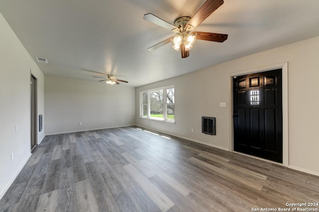 entrance foyer featuring hardwood / wood-style floors, heating unit, and ceiling fan