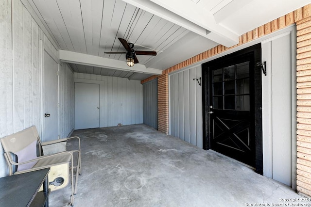 garage with ceiling fan and wood walls