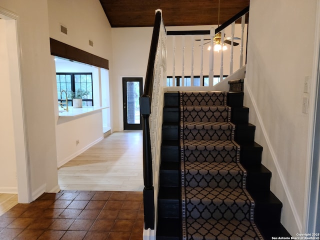 staircase with ceiling fan, wood ceiling, sink, and vaulted ceiling