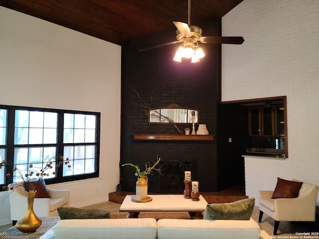 living room with brick wall, a brick fireplace, high vaulted ceiling, and wood ceiling