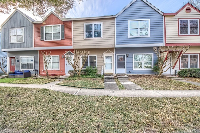 townhome / multi-family property with a front lawn