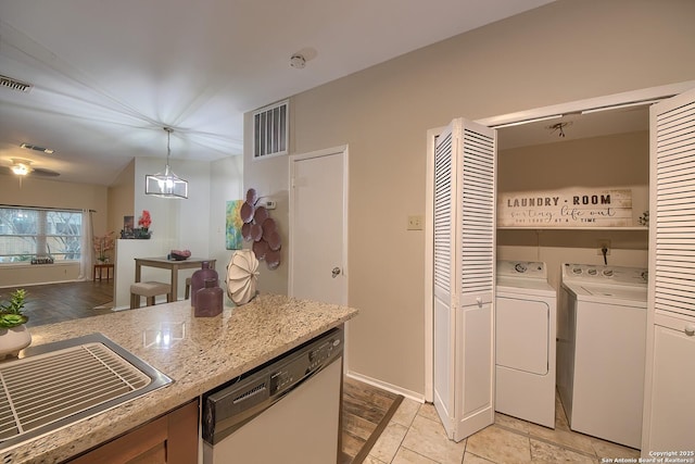 kitchen with pendant lighting, dishwasher, sink, light stone countertops, and independent washer and dryer