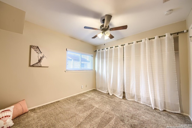 carpeted empty room featuring ceiling fan