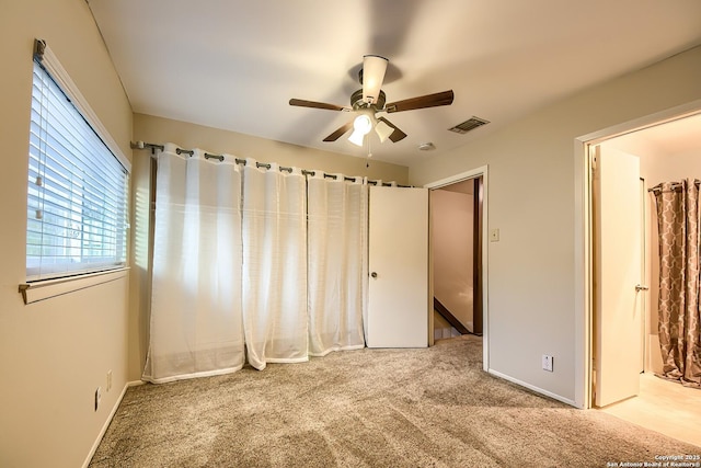 unfurnished bedroom with ceiling fan and light colored carpet