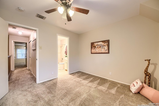 unfurnished bedroom featuring lofted ceiling, ensuite bathroom, ceiling fan, and light colored carpet