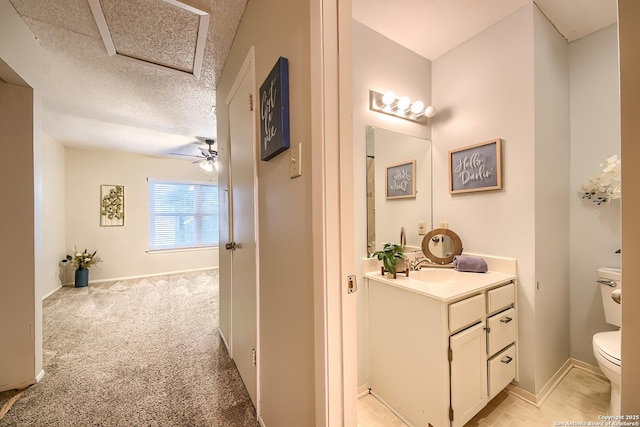 bathroom with vanity, a textured ceiling, toilet, and ceiling fan