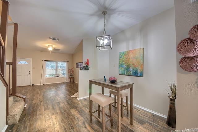 dining space featuring a notable chandelier, lofted ceiling, and dark wood-type flooring