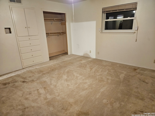 unfurnished bedroom featuring light carpet and a closet