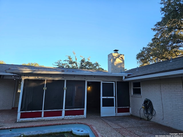 rear view of property with a sunroom