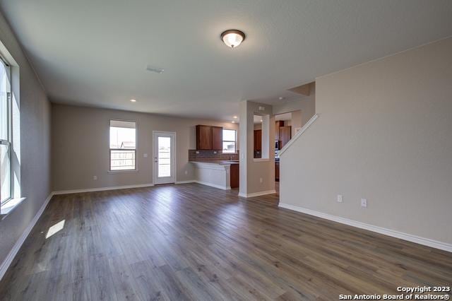 unfurnished living room with dark hardwood / wood-style floors