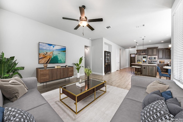 living room with ceiling fan and light hardwood / wood-style floors