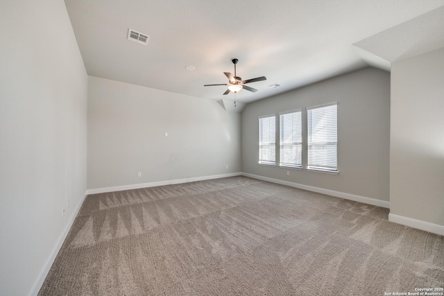 carpeted spare room with vaulted ceiling and ceiling fan