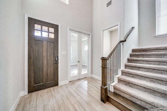 foyer featuring french doors and a towering ceiling