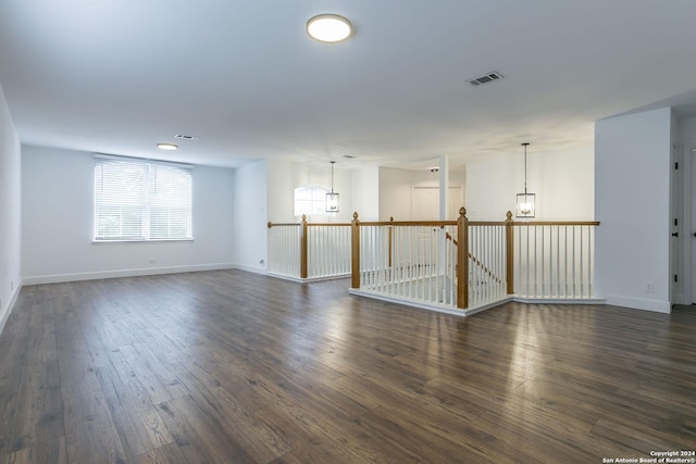 unfurnished room with dark hardwood / wood-style floors and a notable chandelier