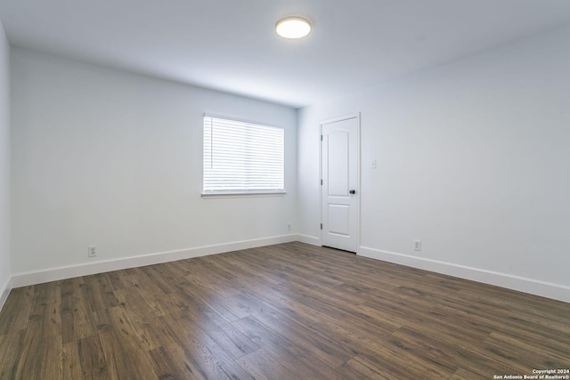 unfurnished room with dark hardwood / wood-style flooring