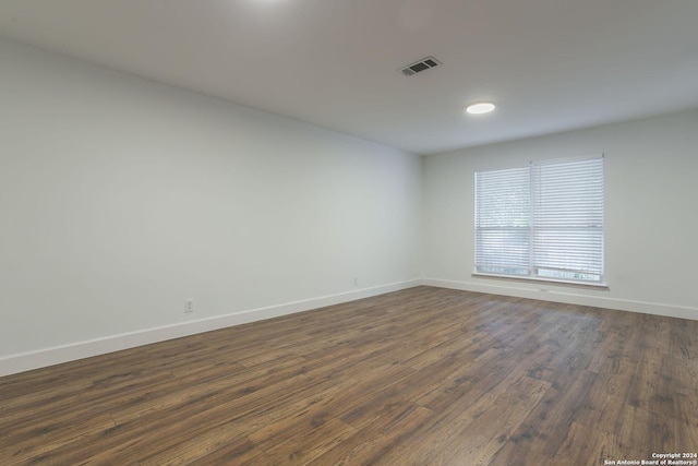 unfurnished room with dark hardwood / wood-style flooring