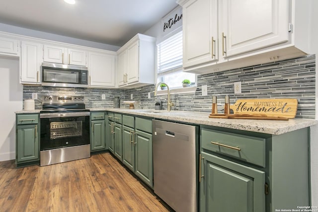 kitchen with backsplash, sink, dark hardwood / wood-style floors, white cabinetry, and stainless steel appliances