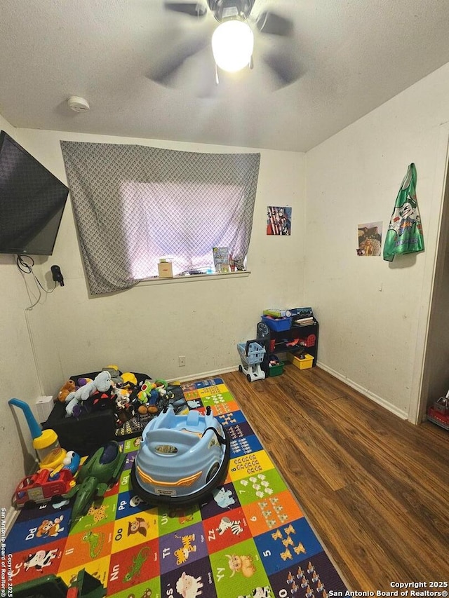 game room with ceiling fan and dark hardwood / wood-style floors