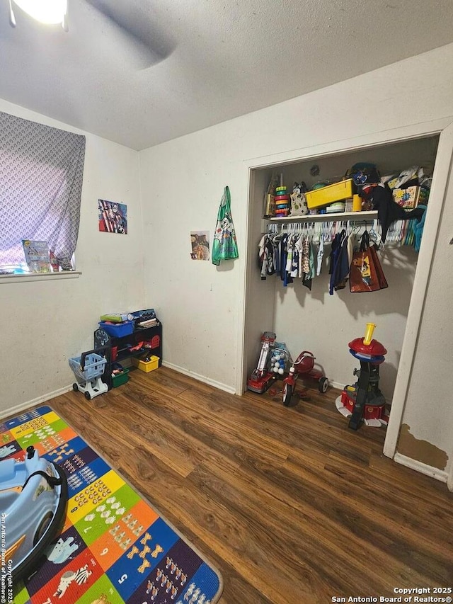 bedroom with dark hardwood / wood-style floors, ceiling fan, and a closet