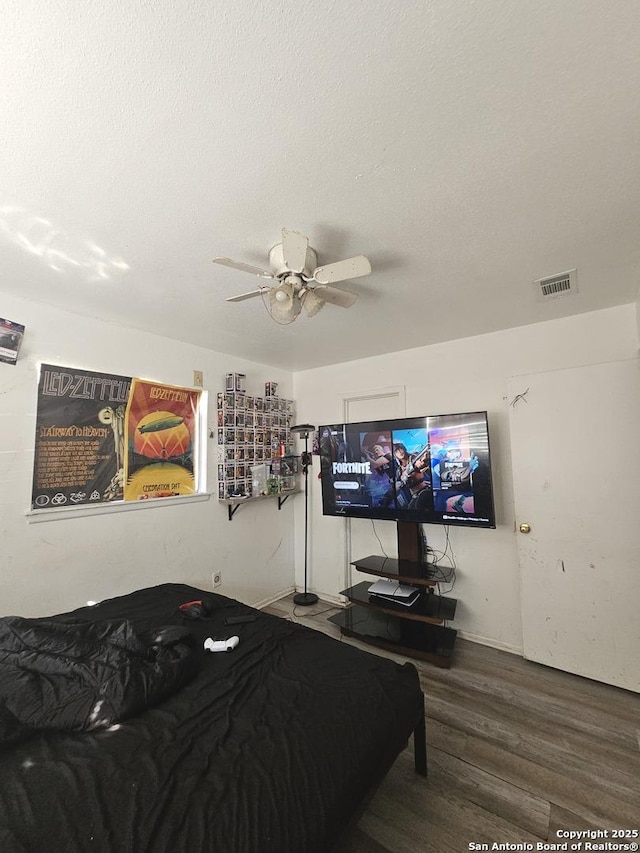 bedroom featuring hardwood / wood-style floors, ceiling fan, and a textured ceiling