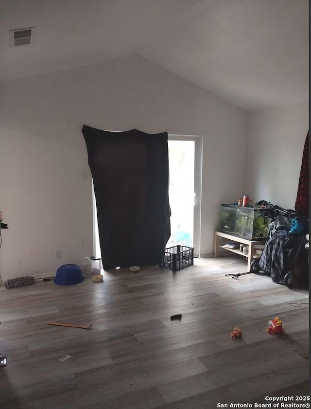 unfurnished room with wood-type flooring and vaulted ceiling