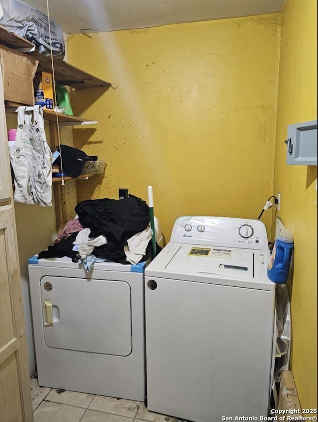 laundry room featuring light tile patterned floors and washer and clothes dryer