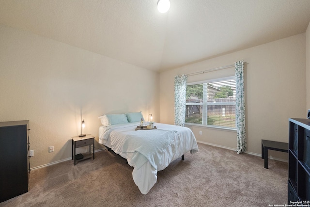 carpeted bedroom with lofted ceiling