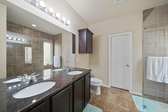 bathroom featuring vanity, toilet, and a shower with door