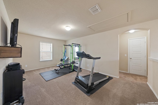 workout room featuring carpet and a textured ceiling