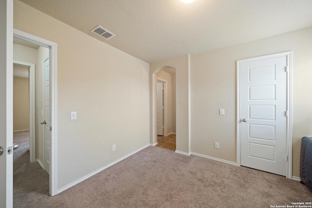 unfurnished bedroom with light carpet and a textured ceiling