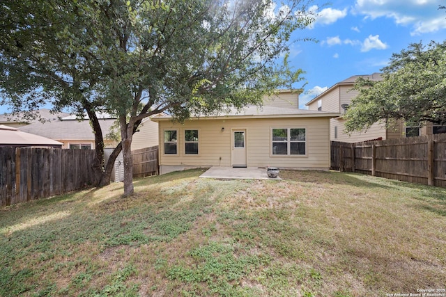 back of house with a yard and a patio