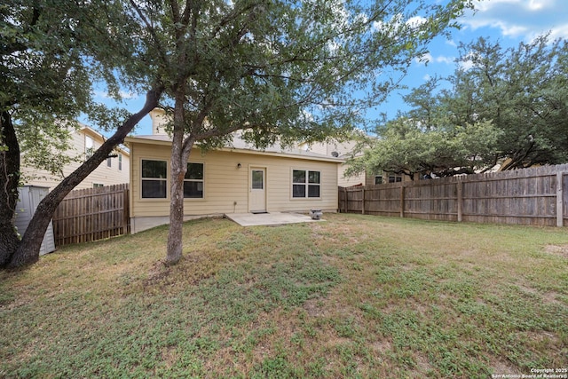 rear view of house featuring a lawn and a patio area