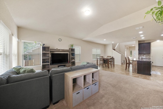 living room with lofted ceiling and sink