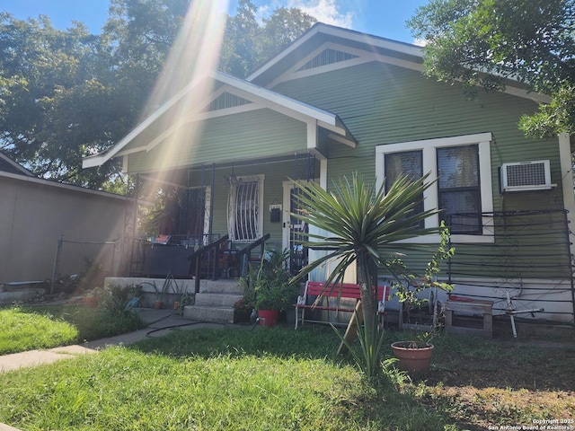 bungalow featuring a porch and a wall mounted AC