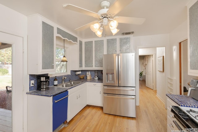 kitchen featuring dishwashing machine, stainless steel refrigerator with ice dispenser, white cabinets, and sink