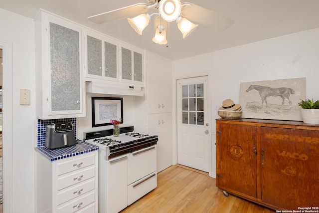 kitchen with white cabinets, ceiling fan, and white gas stove