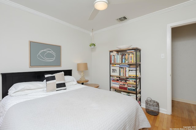 bedroom with ceiling fan, crown molding, and hardwood / wood-style flooring