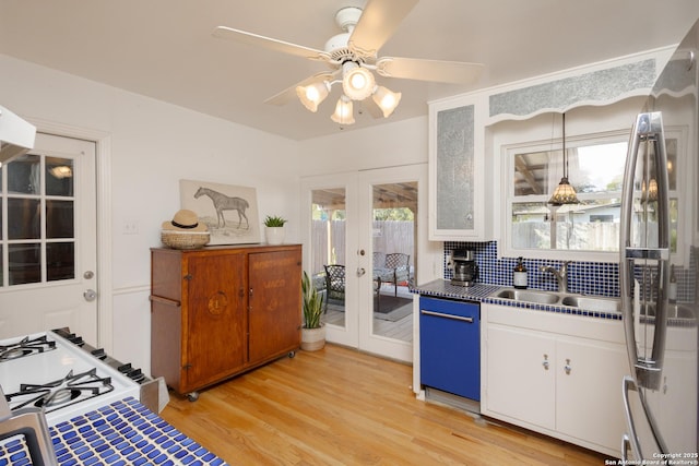 kitchen with ceiling fan, french doors, sink, white cabinets, and light wood-type flooring