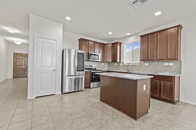 kitchen featuring sink, backsplash, a center island, and appliances with stainless steel finishes