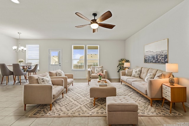 living room with ceiling fan with notable chandelier, a healthy amount of sunlight, and light tile patterned floors