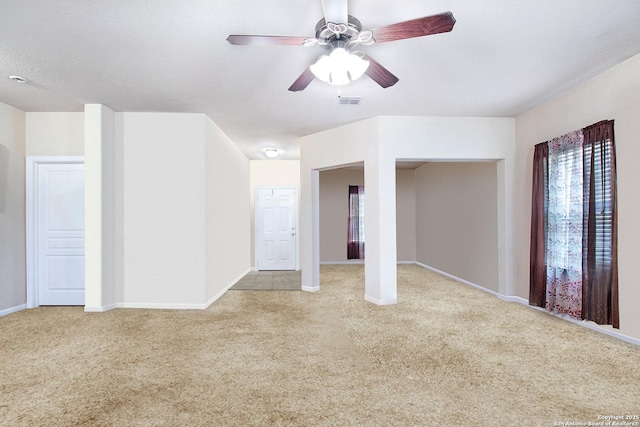 unfurnished room featuring light carpet, a textured ceiling, and ceiling fan