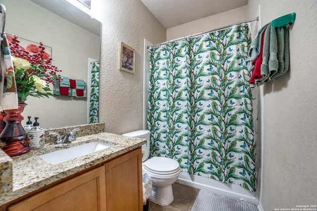 bathroom featuring tile patterned floors, vanity, a textured ceiling, and toilet