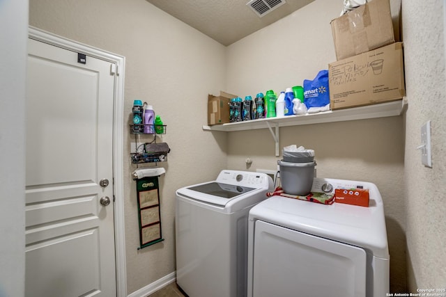 laundry room with separate washer and dryer and a textured ceiling