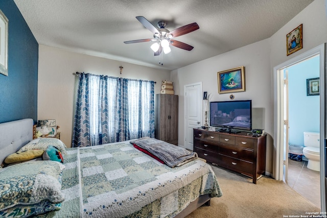 tiled bedroom with a textured ceiling, ensuite bathroom, and ceiling fan