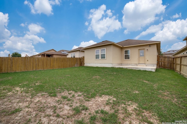 rear view of property with a yard and a patio