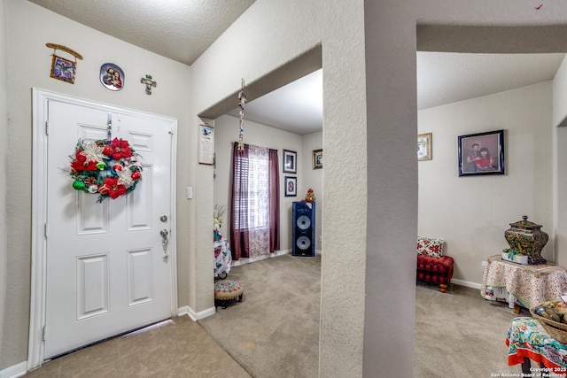 foyer entrance with light carpet and a textured ceiling