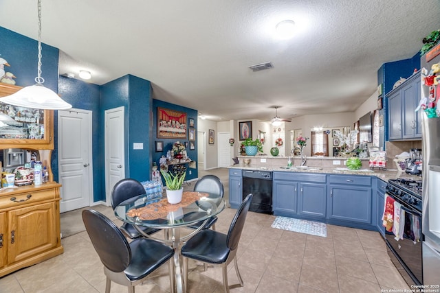 kitchen with kitchen peninsula, ceiling fan, sink, black appliances, and decorative light fixtures