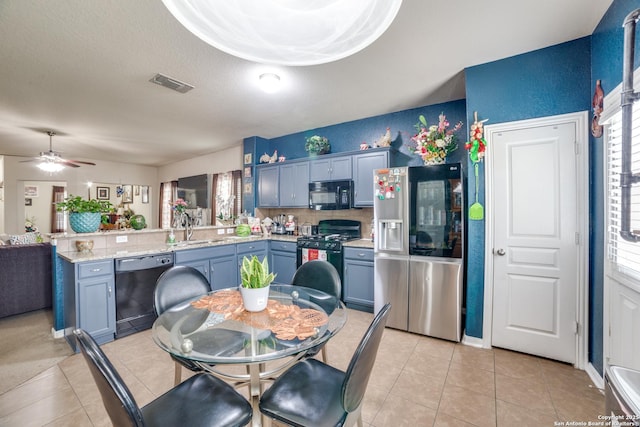 kitchen with ceiling fan, sink, blue cabinetry, light tile patterned floors, and black appliances