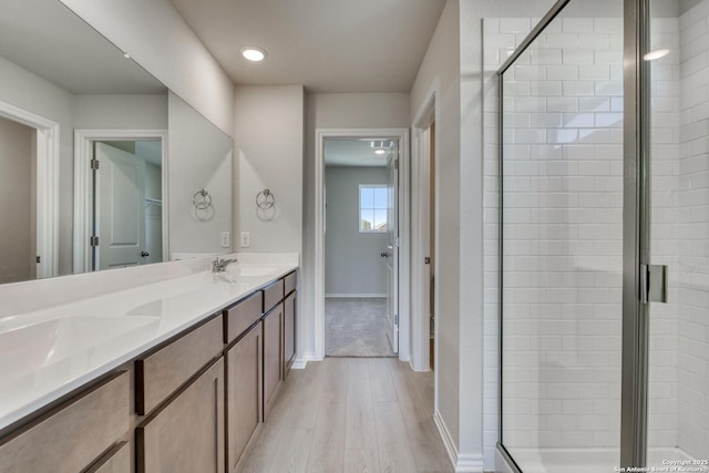 bathroom featuring vanity, an enclosed shower, and hardwood / wood-style flooring